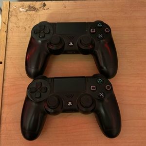 2 black sony playstation 4 dualshock controllers